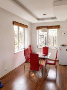 a dining room with a table and red chairs at Sunny House Seaside in Zatoka