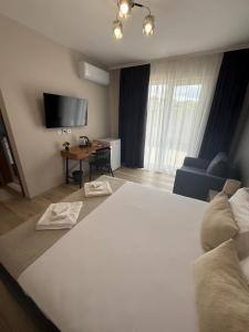 a bedroom with a large white bed and a desk at Къща Грийн Хаус in Chernomorets +18 photos