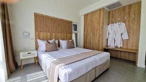 a bedroom with a large bed with a dresser and a robe at Waterside Houses in Ognyanovo +25 photos