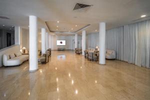 a large lobby with couches and tables and chairs at Anonymous Beach Hotel (Adults 16+) in Ayia Napa