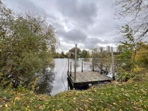 a wooden dock sitting on the side of a lake at La Cabane de l'autre monde in Chavin