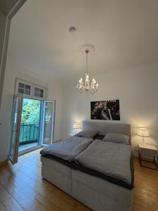 a bedroom with a large bed and a chandelier at Wunderschöne 2 Zimmer Wohnung in Wuppertal in Wuppertal