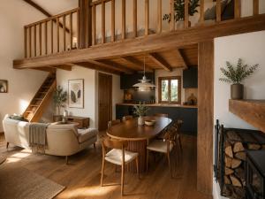 a dining room and living room with a table and chairs at La Cabane de l'autre monde in Chavin