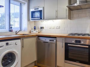 a kitchen with a washer and a dishwasher at Coed Faen in Saint Helens