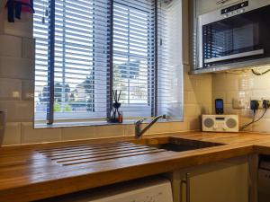 a kitchen with a sink and two windows at Coed Faen in Saint Helens +9 photos