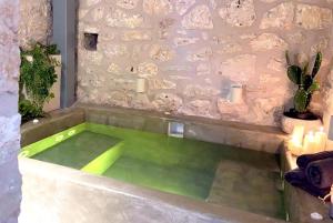 a green bath tub with candles in a room at Metropolis Nextdoor in Vathi