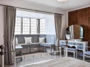 a bedroom with blue furniture and a mirror at Causeway Cottage in Wolsingham +8 photos