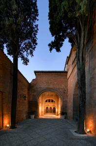 an entrance to a brick building with a tree at Parador de Granada in Granada