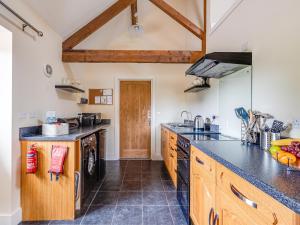 a kitchen with wooden cabinets and black counter tops at The Dairy - Uk10957 in Burlton