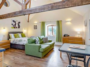 a bedroom with a bed and a green couch at The Dairy - Uk10957 in Burlton