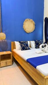 two beds in a room with a blue wall at Golden Nap hostel in Zanzibar City