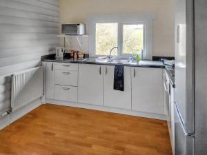 a kitchen with white cabinets and a sink at 2 The Folly's - Uk45188 in Abbotskerswell