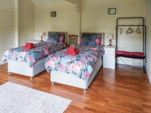 a bedroom with two beds and a mirror at 2 The Folly's - Uk45188 in Abbotskerswell