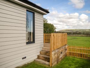 a house with a wooden fence and stairs next to it at Lodge With A View in Steyning