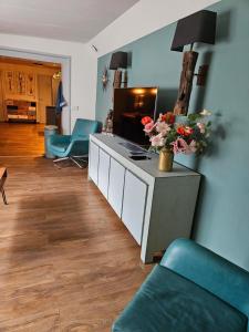 ein Wohnzimmer mit einer Couch und einem Tisch mit Blumen in der Unterkunft SecondHandRose in Sprang-Capelle