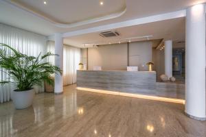 an office lobby with a reception desk and a potted plant at Anonymous Beach Hotel (Adults 16+) in Ayia Napa +126 photos
