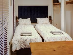a bedroom with two beds and a wooden table at The Wooden Lodge in Byton
