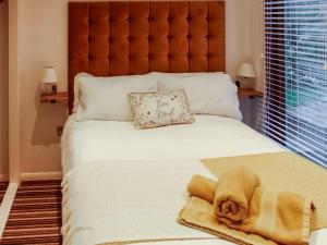 a large bed with a stuffed animal laying on it at The Wooden Lodge in Byton