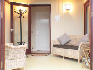 a porch with a bench and wicker chairs and a door at The Wooden Lodge in Byton
