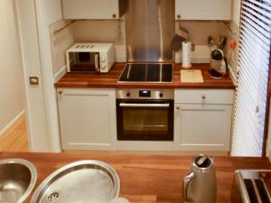 a small kitchen with a sink and a microwave at The Wooden Lodge in Byton