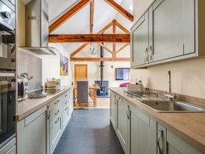 a kitchen with white cabinets and a sink at The Parlour - Uk10958 in Burlton