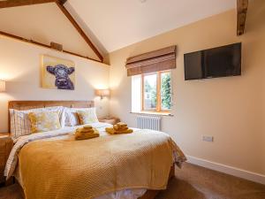 a bedroom with a bed and a tv on the wall at The Parlour - Uk10958 in Burlton +7 photos
