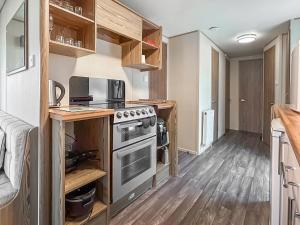 a kitchen with a stove and a microwave at Kjs Holiday Haven in Ayr