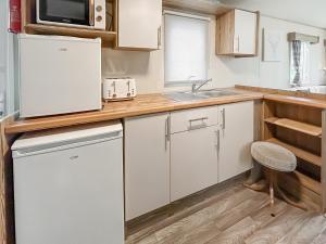 a kitchen with a white refrigerator and a sink at Kjs Holiday Haven in Ayr