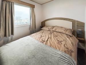 a bedroom with a bed and a window at Kjs Holiday Haven in Ayr