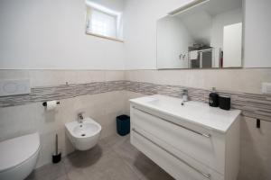 a white bathroom with a sink and a toilet at Predore Lake View Suites in Predore +44 photos