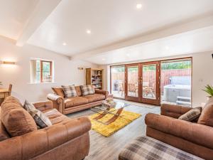 a living room with couches and a table at Stuarts Farm Barn in Westhead