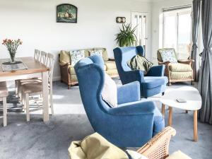 a living room with blue chairs and a table at Lloyds Cottage in Southwell