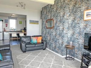 a living room with a couch and a wall at Lloyds Cottage in Southwell