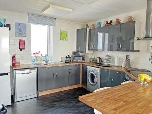 a kitchen with stainless steel appliances and a wooden table at Lloyds Cottage in Southwell