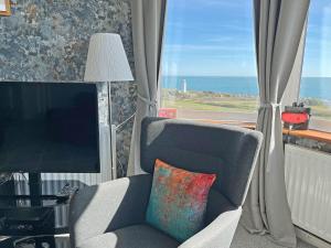 a living room with a chair and a television at Lloyds Cottage in Southwell +24 photos