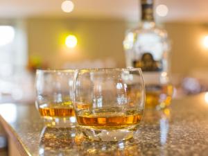 two glasses of whiskey sitting on a counter at Potarch Lodge in Kincardine OʼNeil