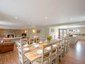 a dining room and living room with a table and chairs at Potarch Lodge in Kincardine OʼNeil