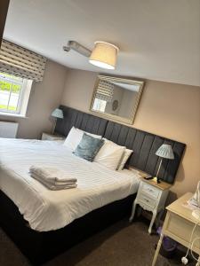 a bedroom with a large bed and a mirror at The Anchor Inn in Sutton Bridge