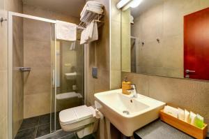 a bathroom with a sink and a toilet and a shower at Hotel Hermes in Krnov