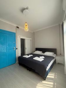 a bedroom with a bed and a blue door at Olivento Pansiyon in Ayvalık
