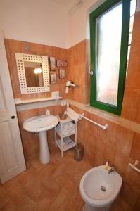 a bathroom with a sink and a toilet and a mirror at La Lomita in Santa Marinella