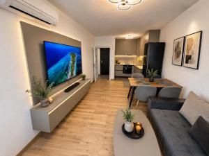 a living room with a couch and a tv on a wall at Boutique apartment green 2 in Plovdiv