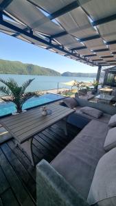 a patio with a table and a view of the water at Casa Aless Eselnita Adults Only 14 plus in Eşelniţa