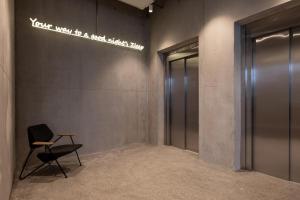 a waiting room with a chair and a elevator at Zleep Hotel Lausanne-Chavannes in Lausanne