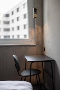 a table and a chair in a room with a window at Zleep Hotel Lausanne-Chavannes in Lausanne