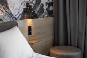 a bedroom with a bed and a chair and a lamp at Zleep Hotel Lausanne-Chavannes in Lausanne