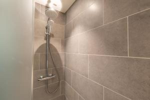 a shower with a shower head in a bathroom at Zleep Hotel Lausanne-Chavannes in Lausanne +20 photos