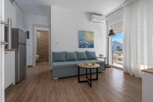 a living room with a couch and a table at SLV Roxani Apartment in Ofrínion +6 photos