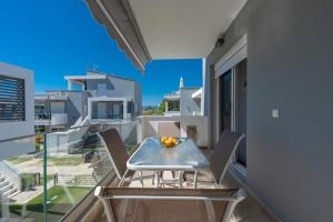 a table on a balcony with a view of a building at SLV Roxani Apartment in Ofrínion