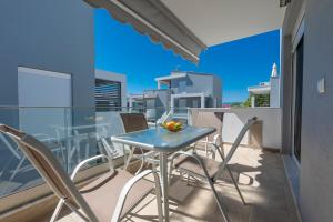a table and chairs on the balcony of a apartment at SLV Roxani Apartment in Ofrínion